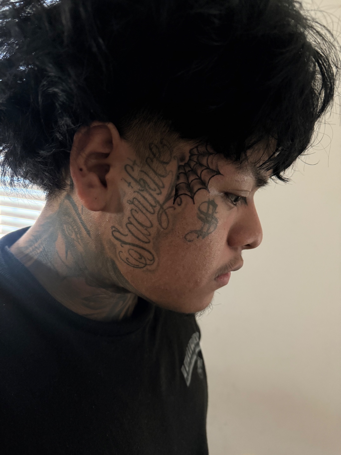 Script and spider web face tattoo